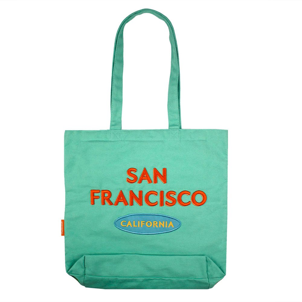 A colorful tote bag with a retro-style San Francisco logo embroidered on a teal green bag
