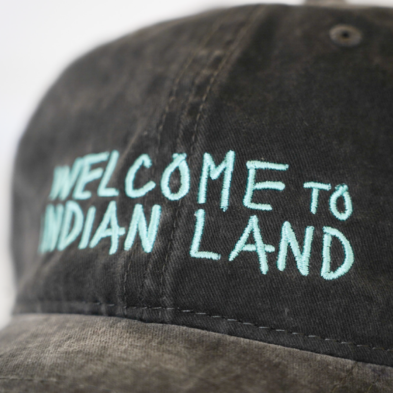 Black cap with 'Welcome to Indian Land' embroidered text in blue