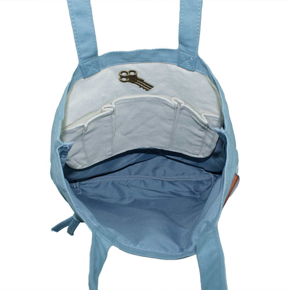 Interior of blue tote bag with an embroidered design of Alcatraz prison key
